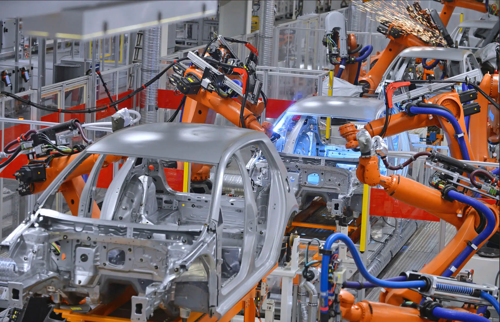 Industrial robots welding vehicle bodies on an automotive production line