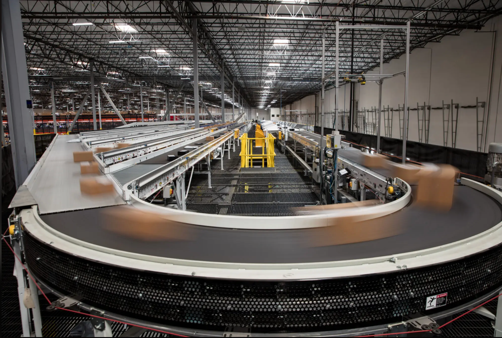 Parcel conveyors curving through a large automated warehouse